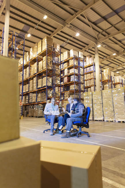 Business people talking in warehouse — Stock Photo