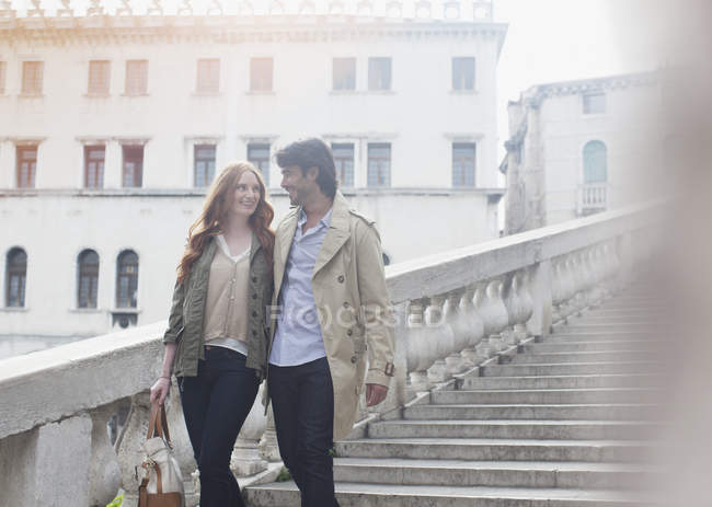 Coppia sorridente che scende le scale a Venezia — Foto stock