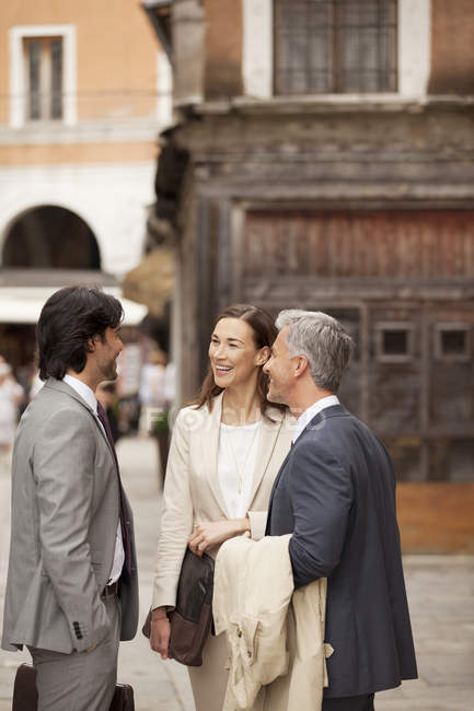 Smiling business people talking in street — Stock Photo