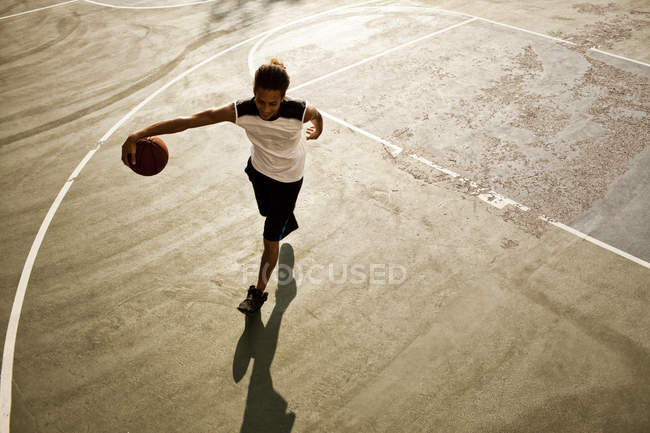 Чоловік грає в баскетбол на корті — стокове фото