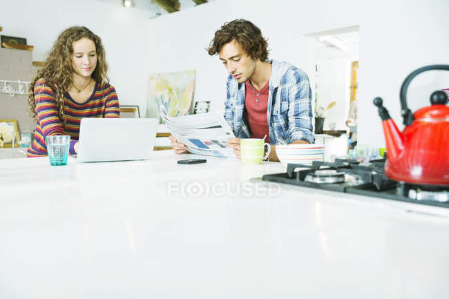 Young happy couple relaxing together in kitchen — Stock Photo