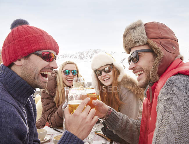 Amici che festeggiano con un drink sulla neve — Foto stock