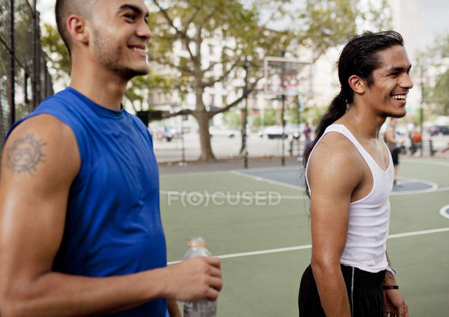Чоловіки сміються на баскетбольному дворі — стокове фото