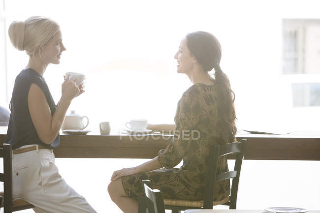 Women having coffee together at cafe — Stock Photo