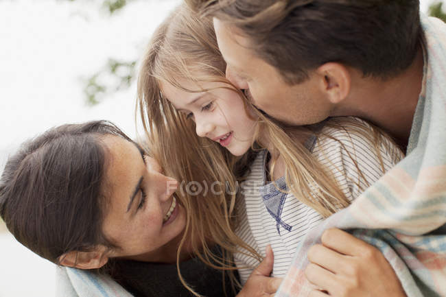 Primer plano de familia feliz envuelta en manta - foto de stock