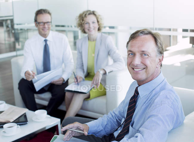 Geschäftsleute lächeln in der Lobby eines modernen Büros — Stockfoto