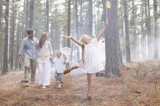Família feliz com redes de borboleta em bosques ensolarados — Fotografia de Stock