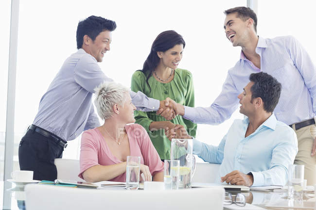 Ділові люди тремтять руками на зустрічі в сучасному офісі — стокове фото