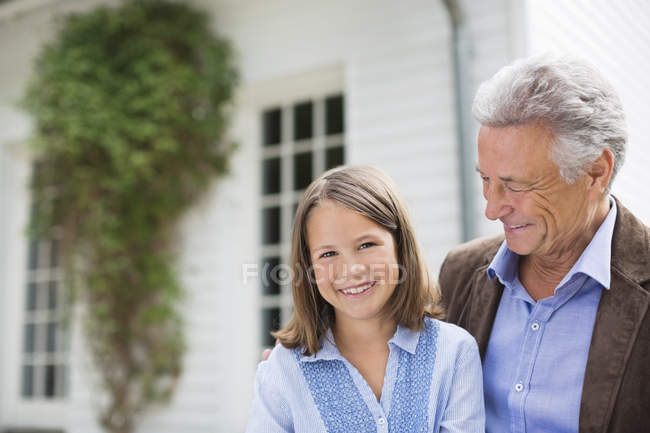 Homme et petite-fille souriant à l'extérieur — Photo de stock