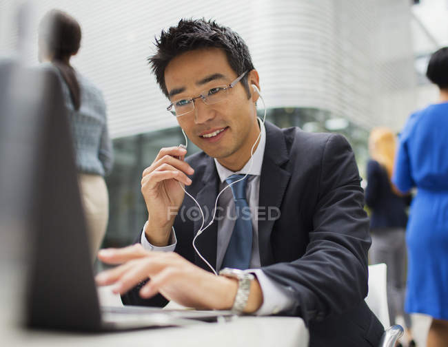 Businessman sitting at table talking on headset — Stock Photo