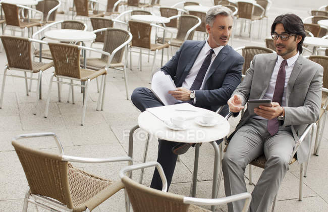 Businessmen meeting at sidewalk cafe — Stock Photo