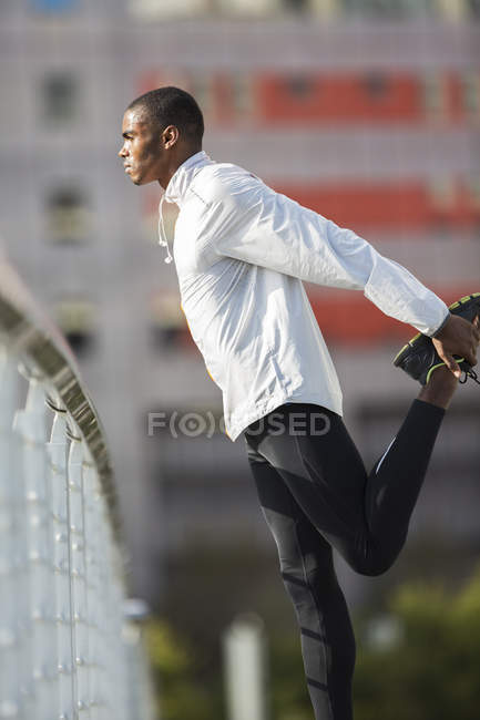 Homem esticando as pernas antes de se exercitar — Fotografia de Stock