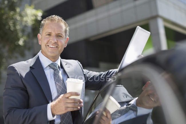 Homem de negócios feliz usando computador tablet ao ar livre — Fotografia de Stock