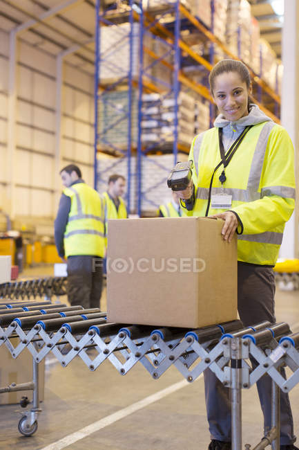 Worker scanning box on conveyor belt in warehouse — Stock Photo
