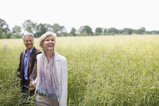 Paar spaziert in Feld mit hohem Gras — Stockfoto