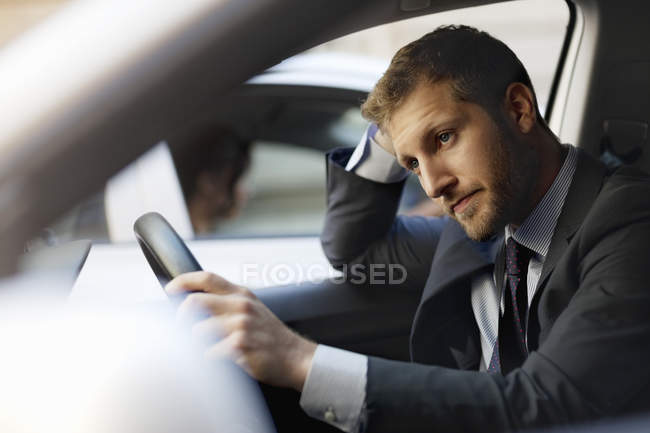 Unhappy businessman stuck in traffic inside car — Stock Photo