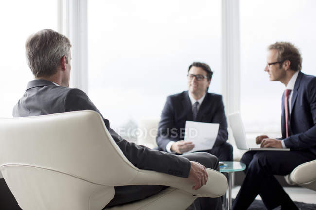 Businessmen talking in lobby at modern office — Stock Photo