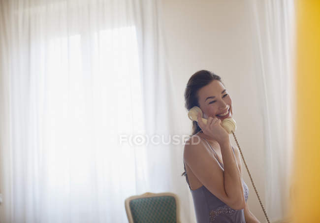 Smiling woman talking on telephone — Stock Photo