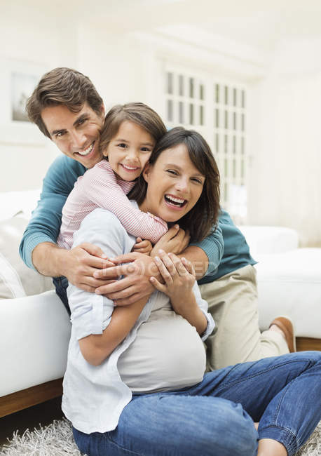 Family hugging in living room — Stock Photo