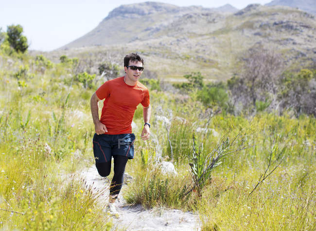 Caucasian young man running on dirt path — Stock Photo