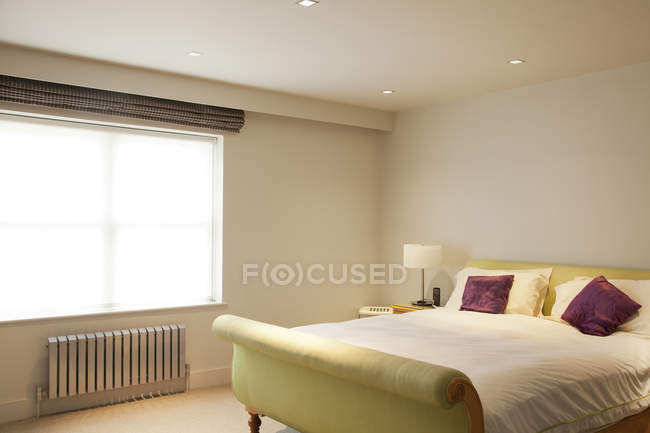 Кровать и радиатор в современной спальне — стоковое фото