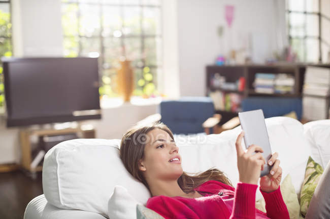 Woman using digital tablet on bed — Stock Photo