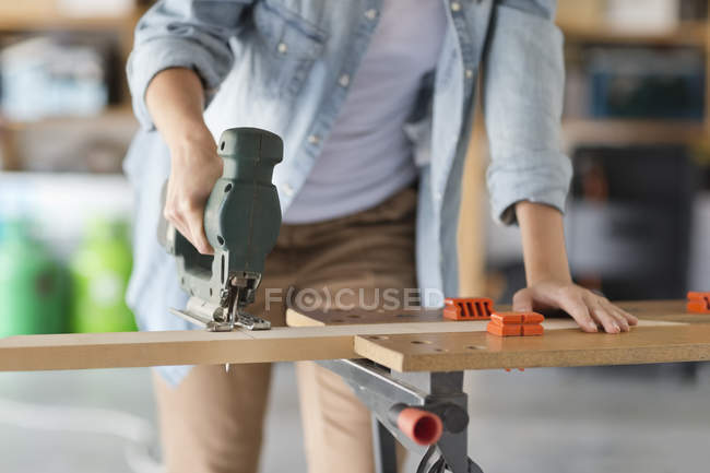 Skillful caucasian woman working in workshop — Stock Photo