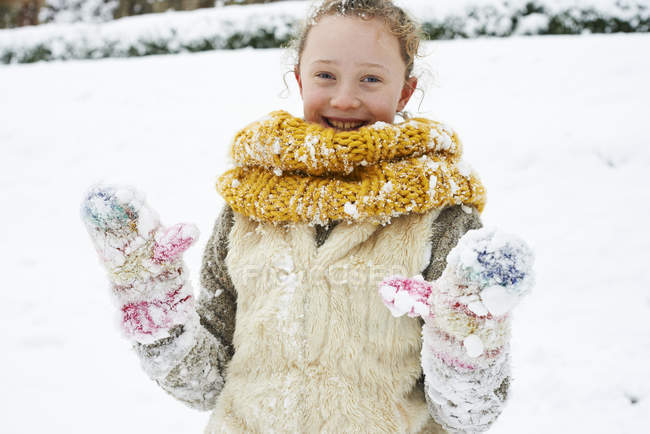 Кавказький щасливі посміхається дівчина грати в снігу — стокове фото