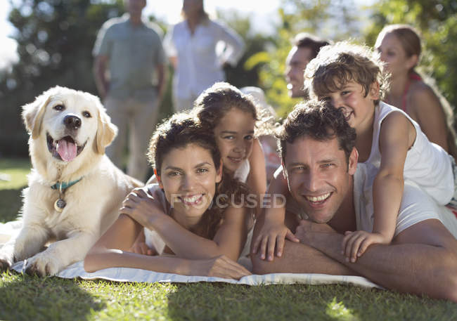 Familia feliz relajarse en el patio trasero con el perro - foto de stock