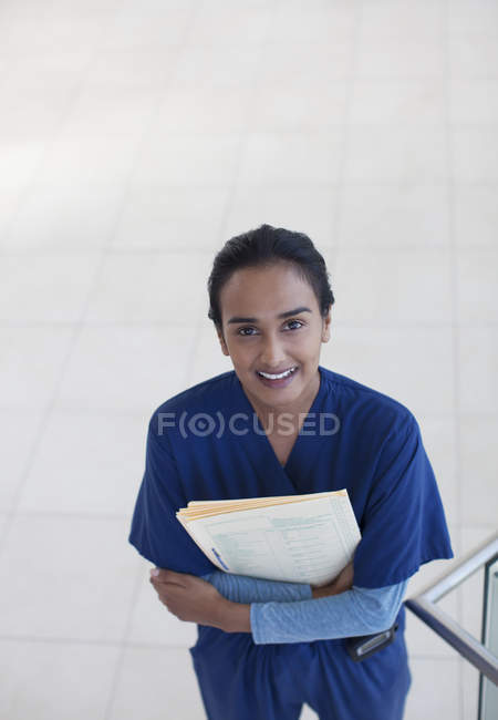 Медсестра держит папки в коридоре больницы — стоковое фото
