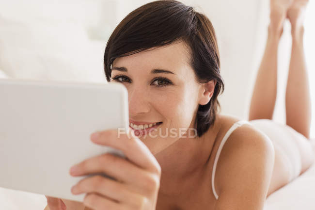 Закрыть портрет улыбающейся женщины с помощью цифрового планшета — стоковое фото