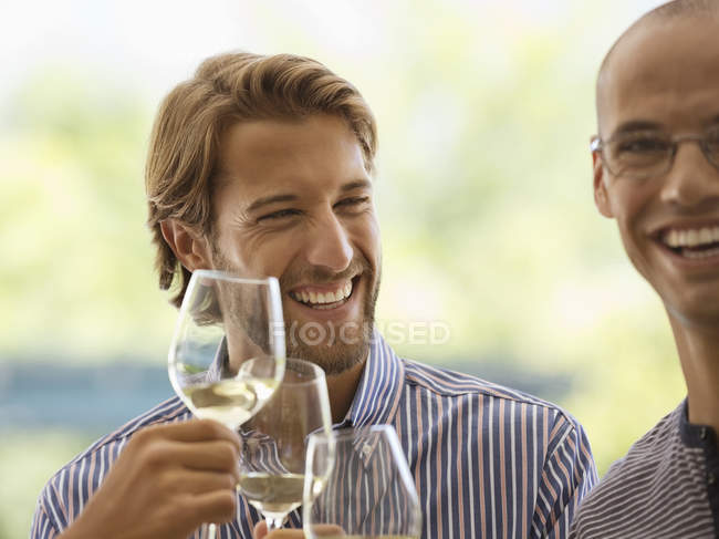 Чоловіки п'ють вино разом у приміщенні — стокове фото