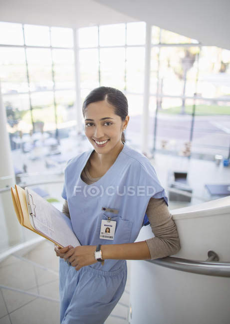 Retrato de enfermera sonriente en la escalera del hospital - foto de stock