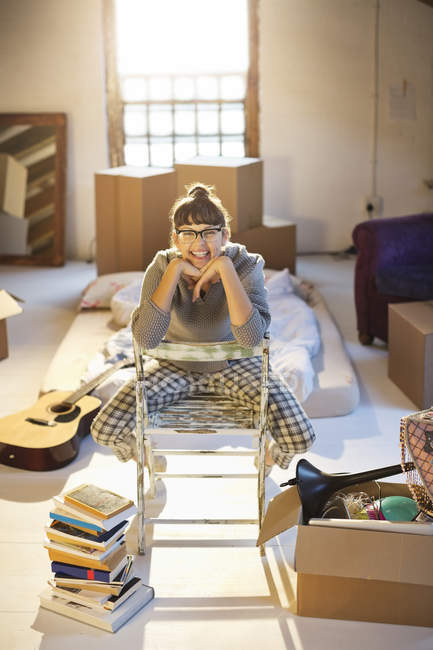 Young happy woman unpacking boxes in attic — Stock Photo