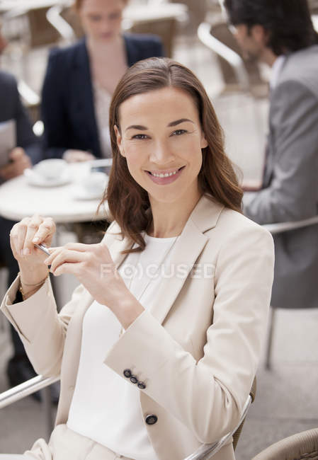 Retrato de una mujer de negocios sonriente en el café de la acera - foto de stock