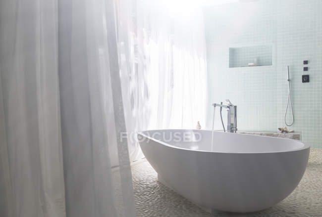 L'eau coulant dans la baignoire dans la salle de bain moderne — Photo de stock