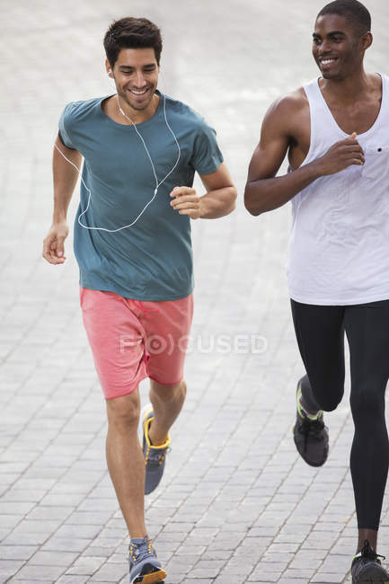 Männer rennen gemeinsam durch die Straßen der Stadt — Stockfoto