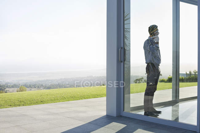 Vista lateral do empresário em pé na janela do escritório — Fotografia de Stock