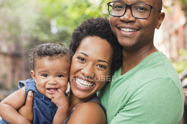 Family smiling together on city street — Stock Photo