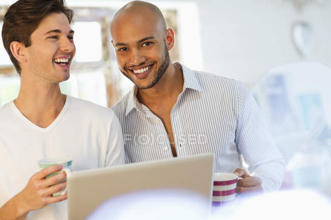 Young happy men having coffee together — Stock Photo