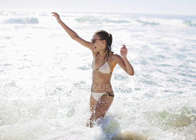 Feliz mulher caucasiana entusiasta espirrando no oceano — Fotografia de Stock