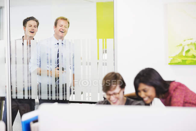 Businessmen eavesdropping on colleagues at modern office — Stock Photo
