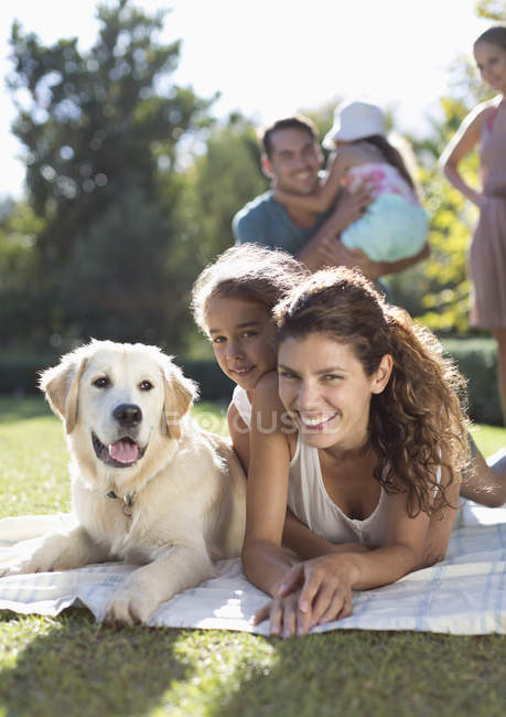 Mother, daughter and dog laying in grass — Stock Photo