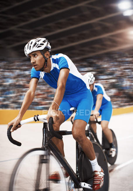 Track cyclists riding in velodrome — Stock Photo