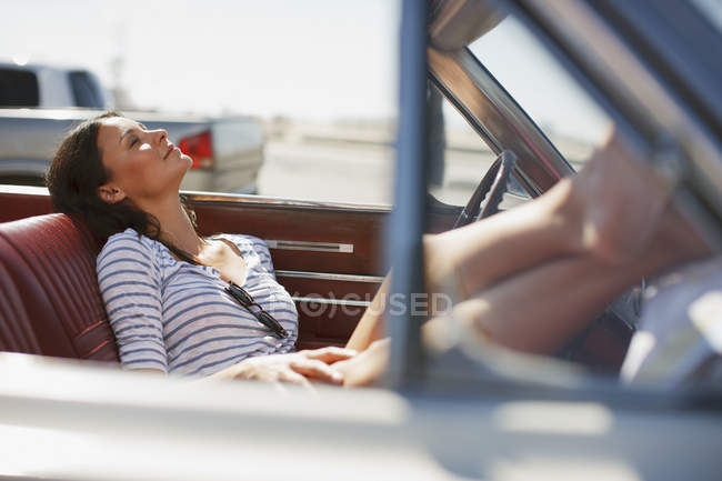 Lächelnde Frau entspannt sich im Cabrio — Stockfoto