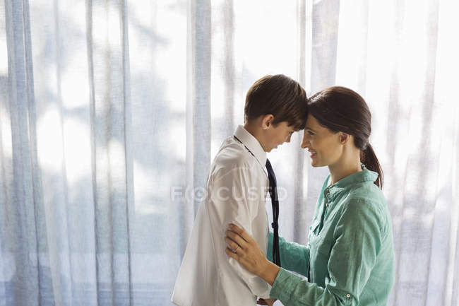 Mother and son touching foreheads at window — Stock Photo