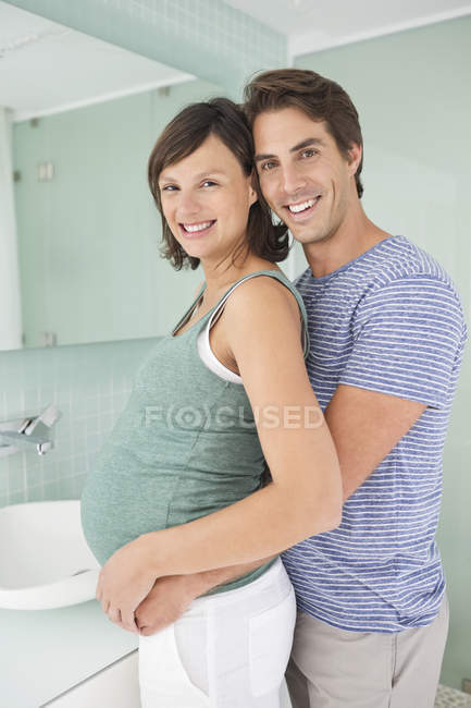 Усміхнена пара обіймає у ванній кімнаті — стокове фото