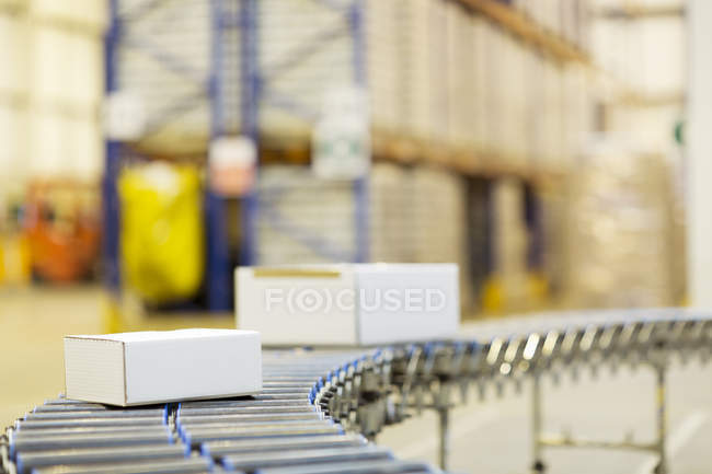 Packages on conveyor belt in warehouse — Stock Photo