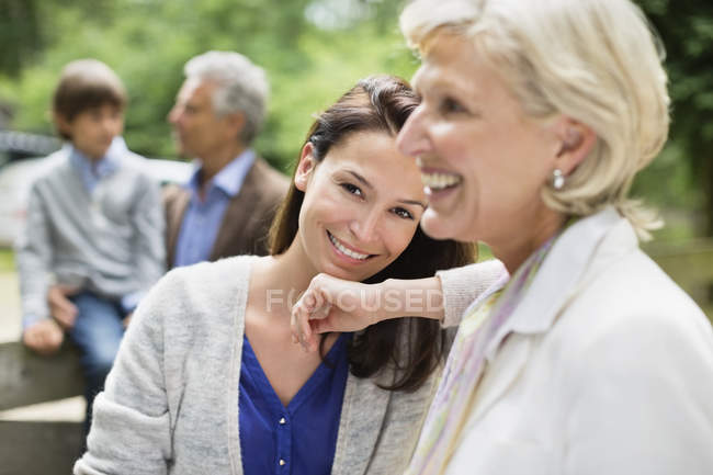 Mother and daughter smiling together outdoors — Stock Photo