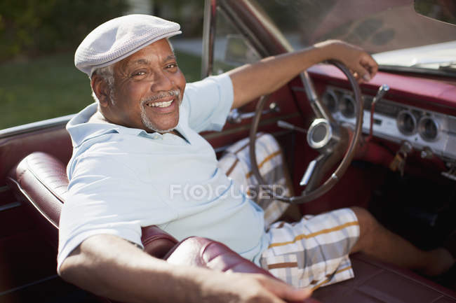 Улыбающийся пожилой мужчина за рулем кабриолета — стоковое фото